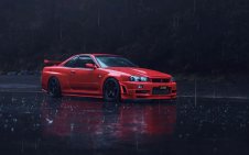 Red Nissan parked on the road under the rain